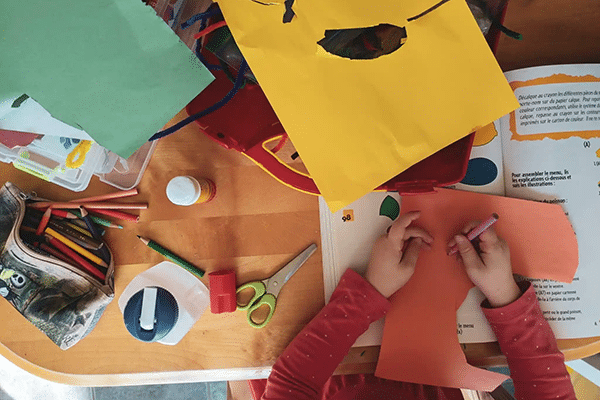 Person draws on paper cutout as part of an art activity