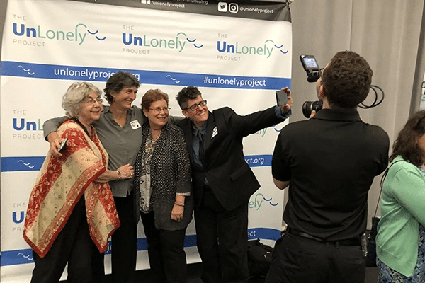 Four people take a selfie at an UnLonely event